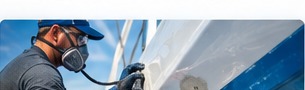 Technician sanding a boat hull for fiberglass repair